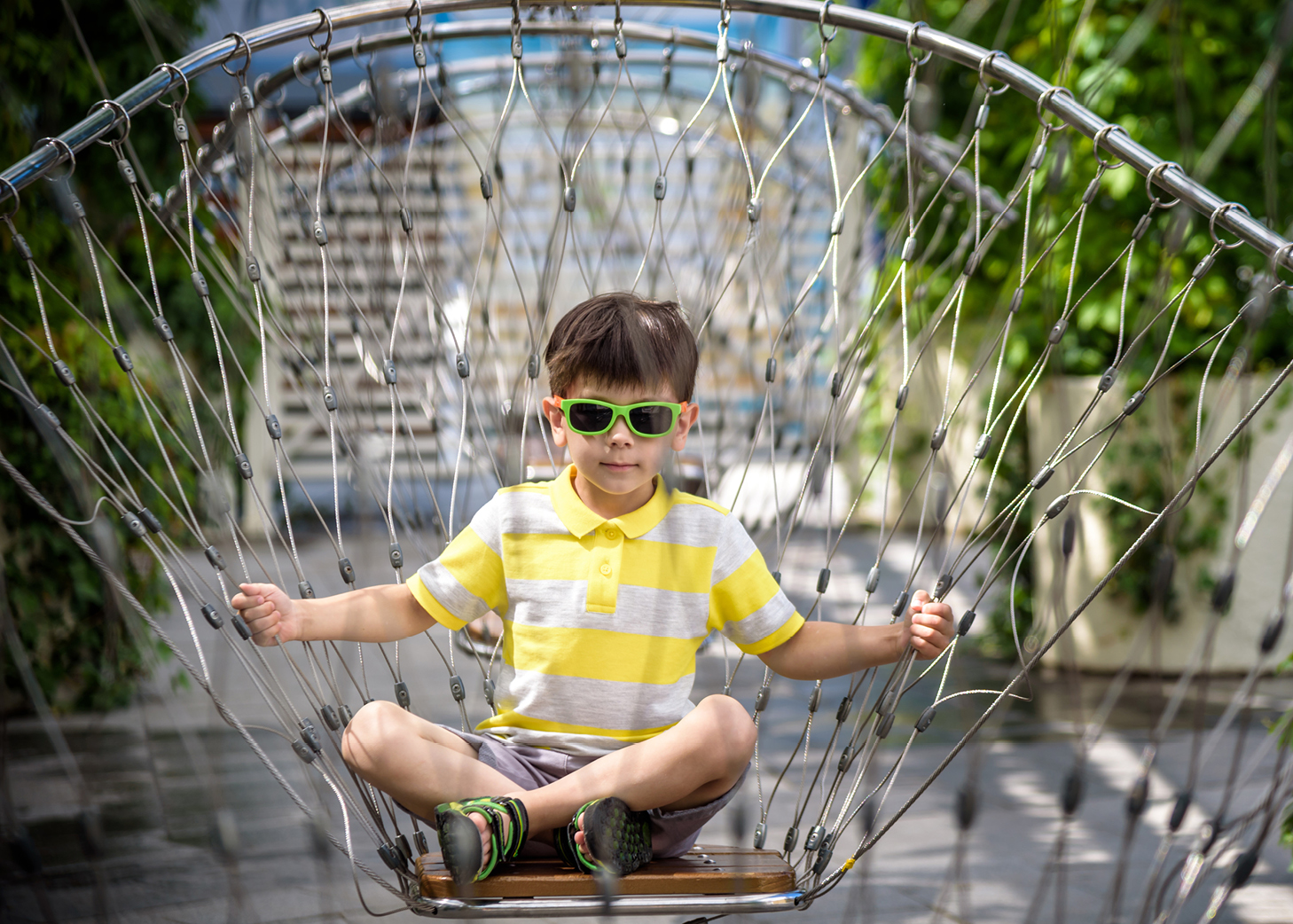 Boy sitting on a fancy chair in an outdoor square