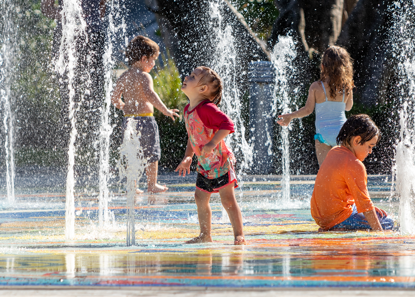 Children playing in a splashpad on a sunny day